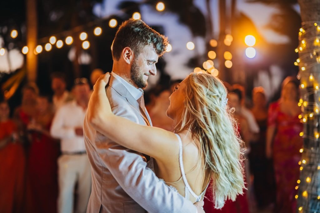 A couple dancing beneath warm string lights